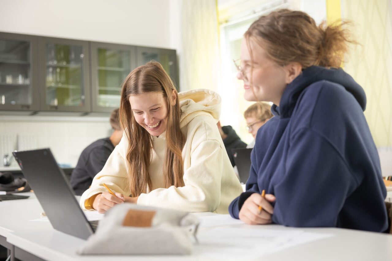 Kuva on koristekuva. Kaksi tyttöä ratkoo yhdessä tehtävää.