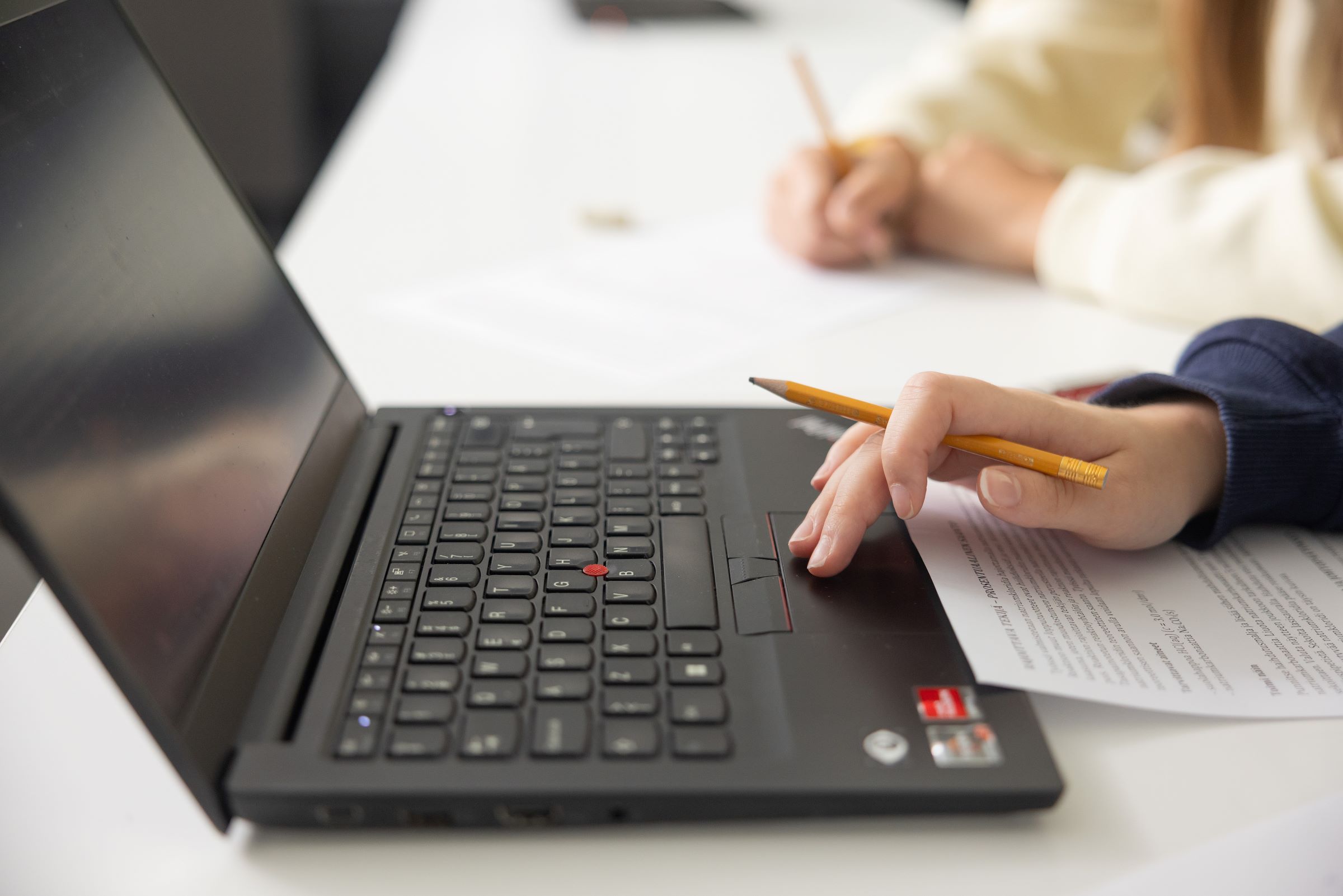 Kuva on koristekuva. Tietokone, kynä ja moniste kuvassa.